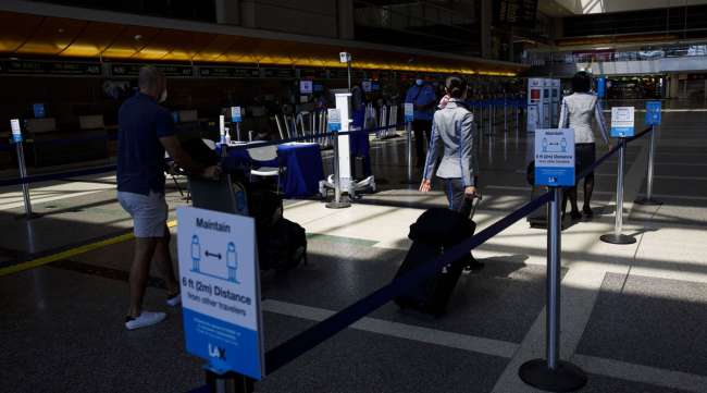 Passengers walk past thermal imaging cameras at LAX on July 7.