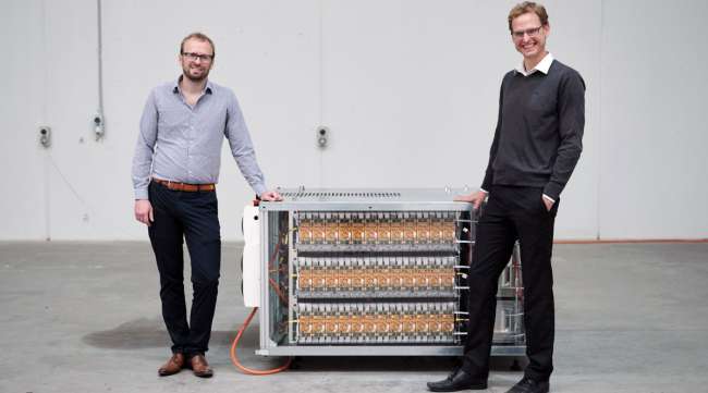 Daniel Crowley and Valentin Muenzel, co-founders of Relectrify, stand beside their battery energy storage unit in Australia on Jan. 17.