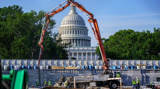 A concrete pump frames the Capitol Dome during renovations