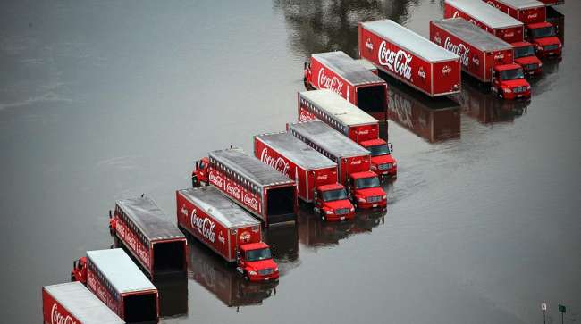 Coca-Cola delivery semi-trailer trucks sit in floodwater in Lumberton, Texas