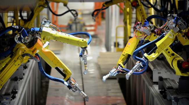 Robotic painting arms are tested in the underbody sealing and coating area of the Chrysler Group Assembly Plant in Sterling Heights, Mich.