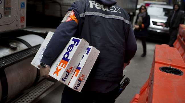 The driver for an independent contractor to FedEx Corp. delivers packages in Midtown Manhattan in New York.