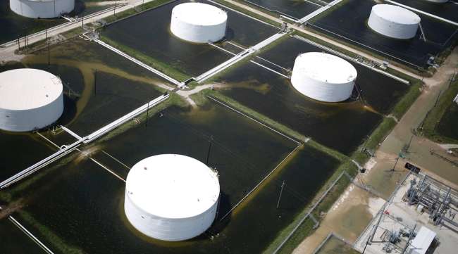 Rainwater surrounds oil refinery storage tanks