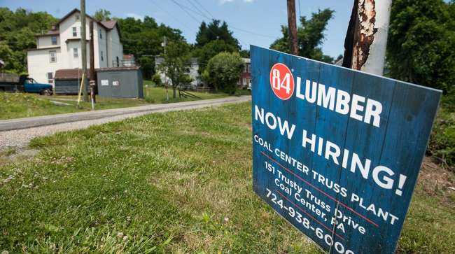 A "Now Hiring" sign stands outside the 84 Lumber Co. California Truss Plant in Coal Center, Pennsylvania, U.S., on Friday, June 9, 2017. One of the nation's largest building-supply chains, 84 Lumber Co., spends millions on ads to drive home its message th
