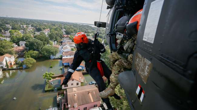 Brian Archibald, a rescue specialist assigned to the South Carolina Helicopter Aquatic Rescue Team Delta in McEntire Joint National Guard Base, S.C., points to a someone who may need help on Aug. 31, 2017 in Port Arthur, Texas.