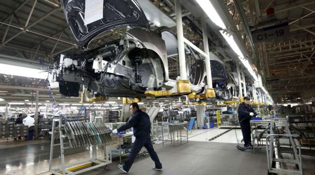 Workers assemble cars on the production line of a Hyundai plant in Beijing, China, in March 2013.