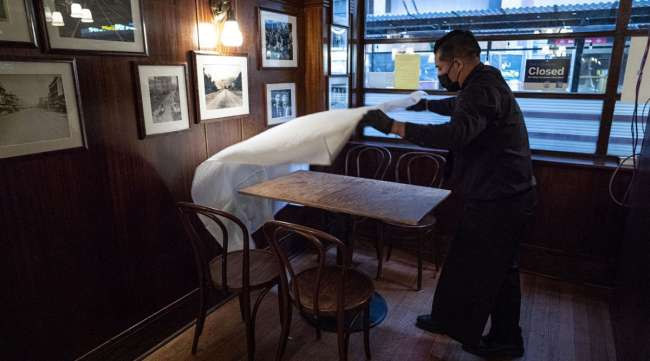 A workers puts down a table cloth at a restaurant in San Francisco. (David Paul Morris/Bloomberg News)