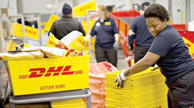 Employees sort crates of packages at a DHL facility in Chicago. (Daniel Acker/Bloomberg News)