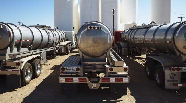 Tanker trucks sit in front of storage silos in Sunray, Texas