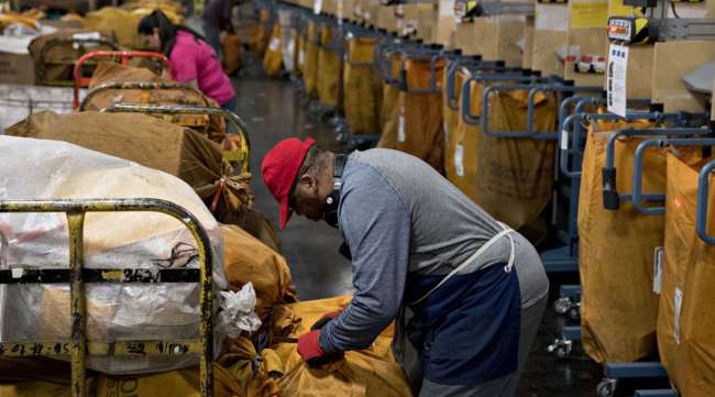 A worker seals a mail sack at the USPS Merrifield processing and distribution center in Merrifield, Va., in December 2018.