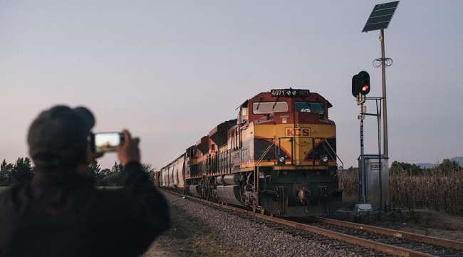 A person photographs a Kansas City Southern freight train in Mexico.