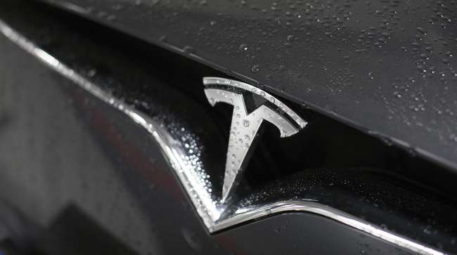 Raindrops rest on the badge of Tesla Inc. Model X electric automobile in a parking lot in Frankfurt, Germany, on Friday, Aug. 11, 2017.