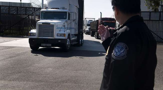 A U.S. Customs and Border Protection official directs trucks heading from the United States to Mexico at the Otay Mesa Port of Entry.