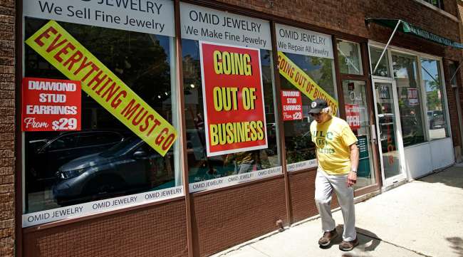 A man walks past an Illinois retail store going out of business due to the pandemic on June 23.