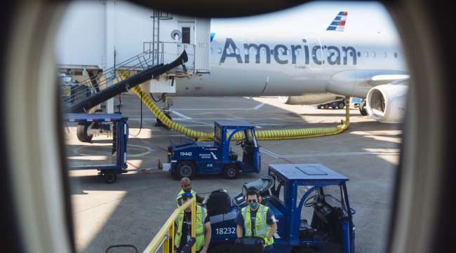 Workers load bags onto an American Airlines flight at DFW Airport on Sept. 28.