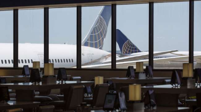 United Airlines planes stand past an empty waiting area for travelers at Newark International Airport on June 9.