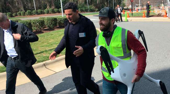 Andreas Raptopoulos, CEO of UPS partner Matternet, walks next to an operator carrying a drone used for medical specimens delivery in North Carolina in March 2019.