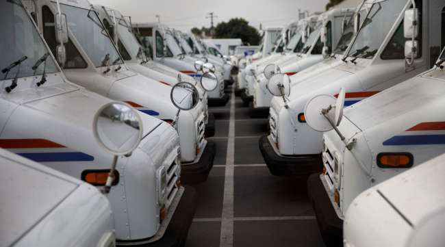 USPS delivery vehicles sit outside a post office in California in August 2020. (Patrick T. Fallon/Bloomberg News)