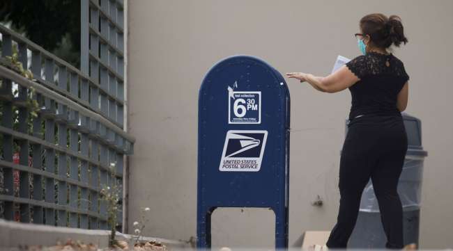 A person approaches a USPS collection box in Los Angeles on Aug. 17.