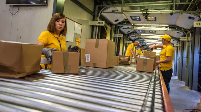 Workers process boxes at a distribution center