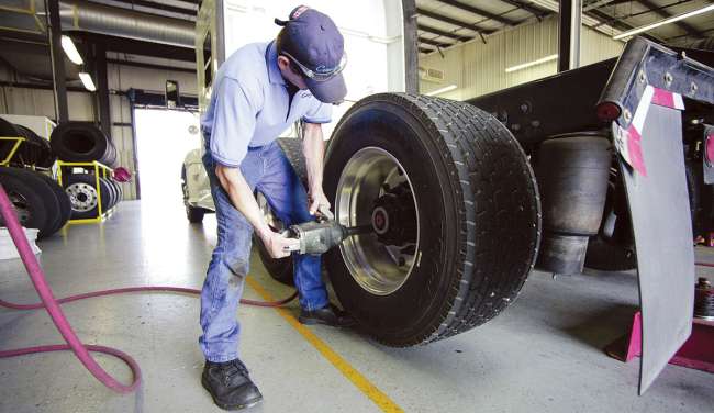 A technician inspects a wide-base tire.