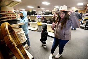 A shopper browses hats