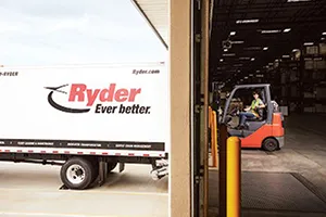 A Ryder employee unloads a truck using a forklift