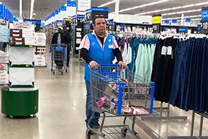 Walmart employee pushing a cart