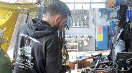 Truck technician welding truck parts