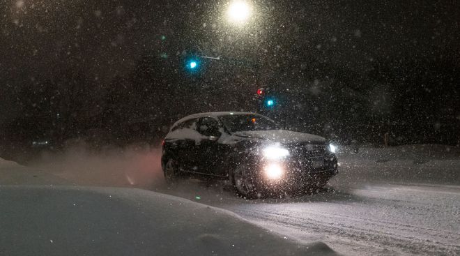 A vehicle drives through a snowstorm in Minneapolis