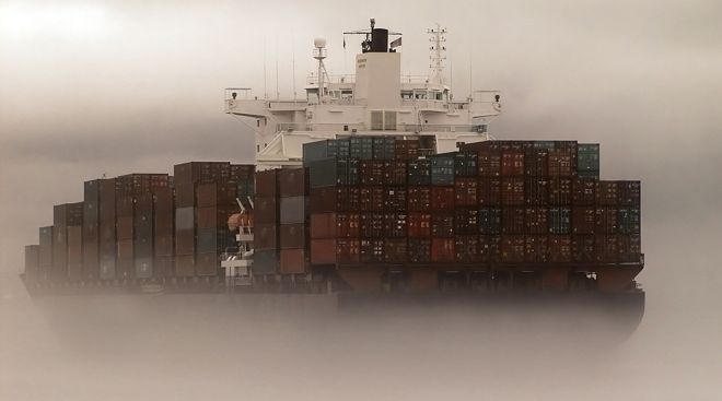 A cargo ship clouded in fog