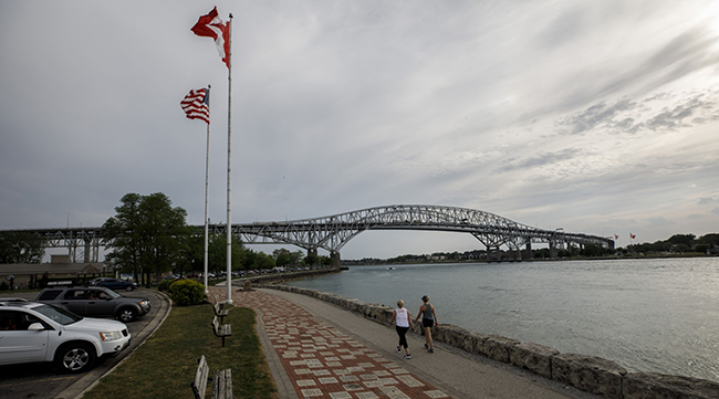 People walk along the waterfront near the Bluewater Bridge