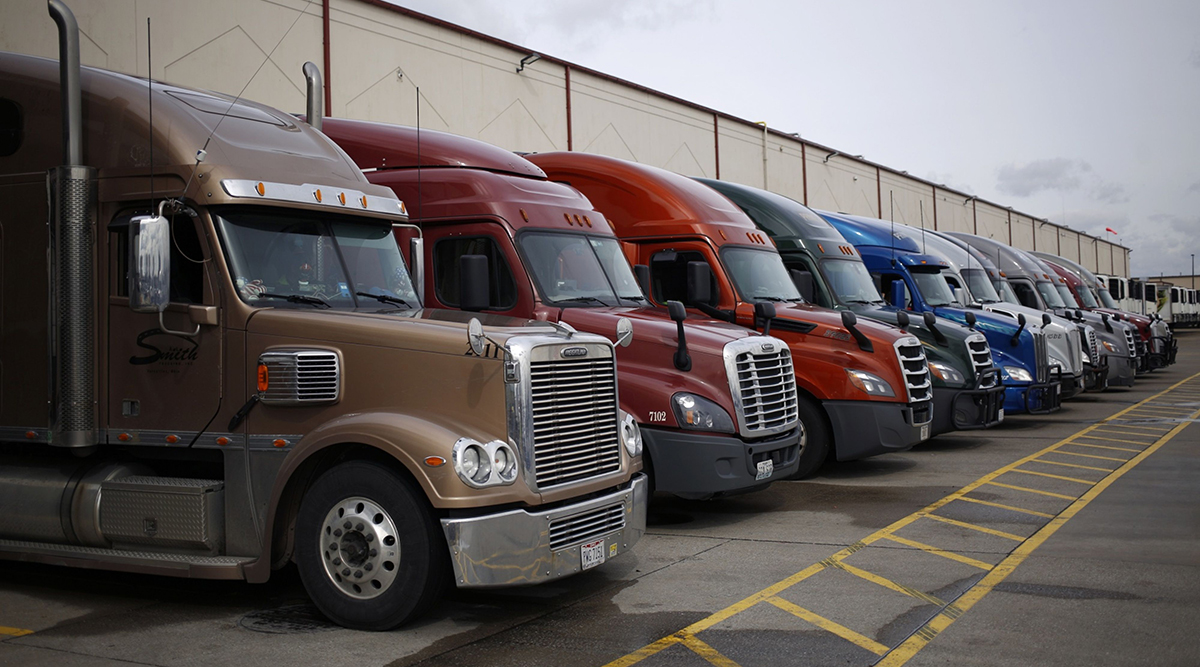 Semi-trailer trucks sit parked