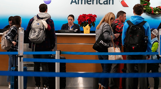 Travelers check in at an airline ticket counter
