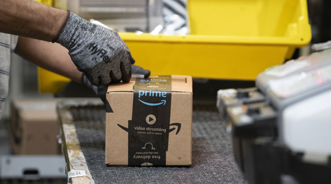 A worker places a label on a box at the Amazon fulfillment center in Baltimore, Md.