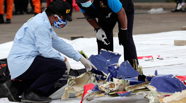 Indonesian investigators on Jan. 10 inspect parts of Sriwijaya Air Flight 182, which crashed off the coast of Jakarta on Jan. 9.