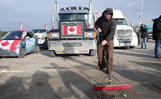 A protester sweeps up in preparation of police enforcing an injunction against their demonstration in Windsor Feb. 12.