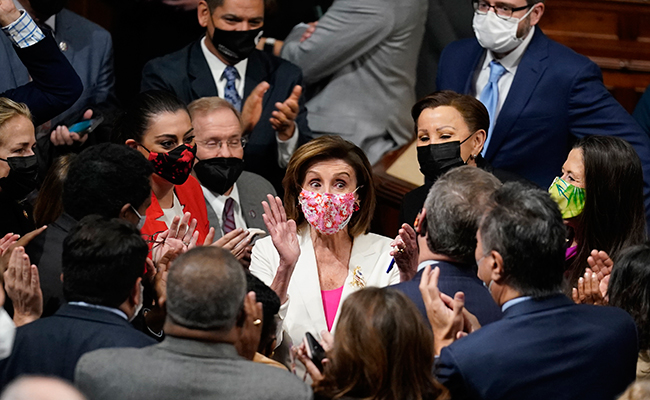 Speaker of the House Nancy Pelosi (D-Calif.) and other Democrats celebrate the House passage of President Joe Biden's expansive social and environment bill