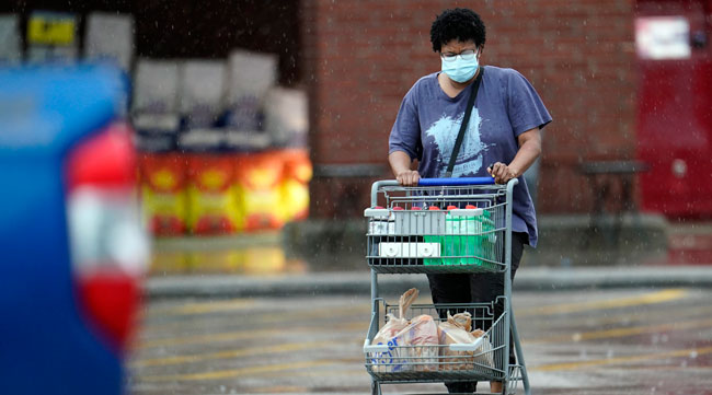 A shopper wears a mask while pushing a grocery cart in Houston on June 25.
