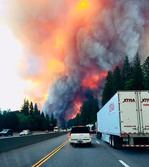 A fire rages as motorists travel on Interstate 5 near Lake Shasta, Calif.