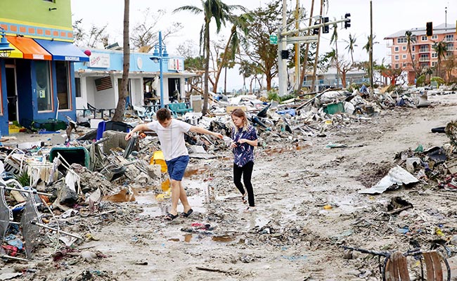 Two young adults explore a section of destroyed businesses at Fort Myers Beach