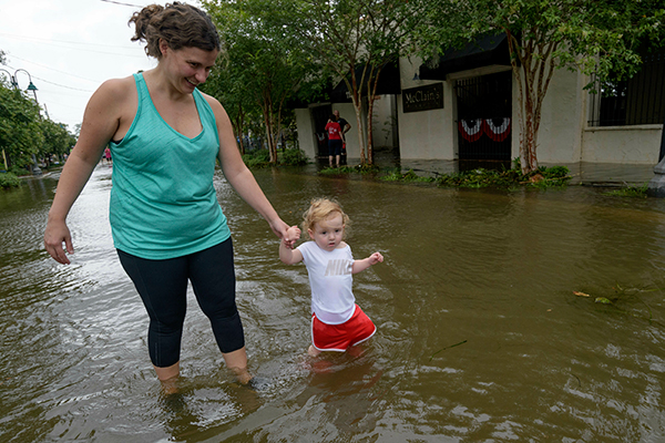 Mother and daughter wade through storm surge in Louisiana