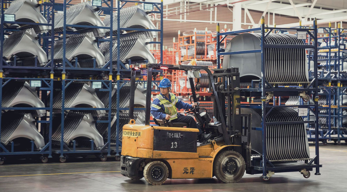 An employee uses a forklift to transport vehicle panels in a Chinese automobile plant in 2018.