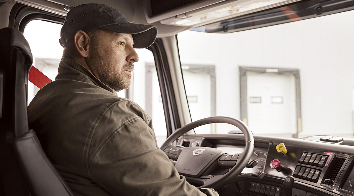 A driver in the cab of a Volvo truck