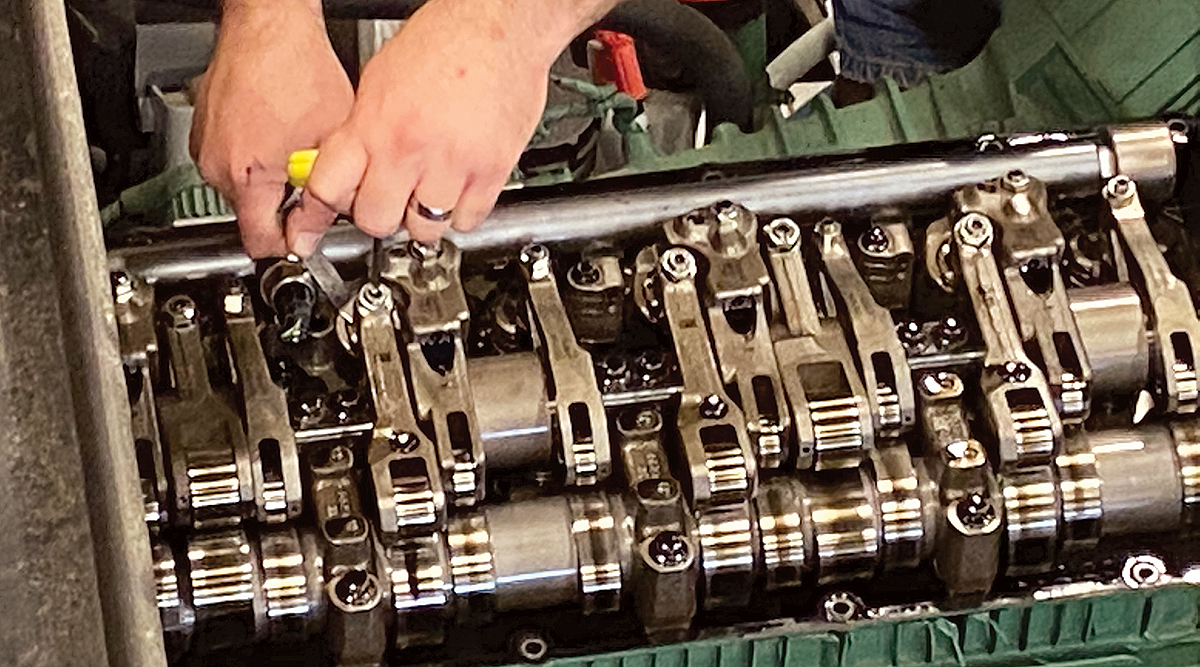 A technician adjusts overhead valves on a Volvo engine