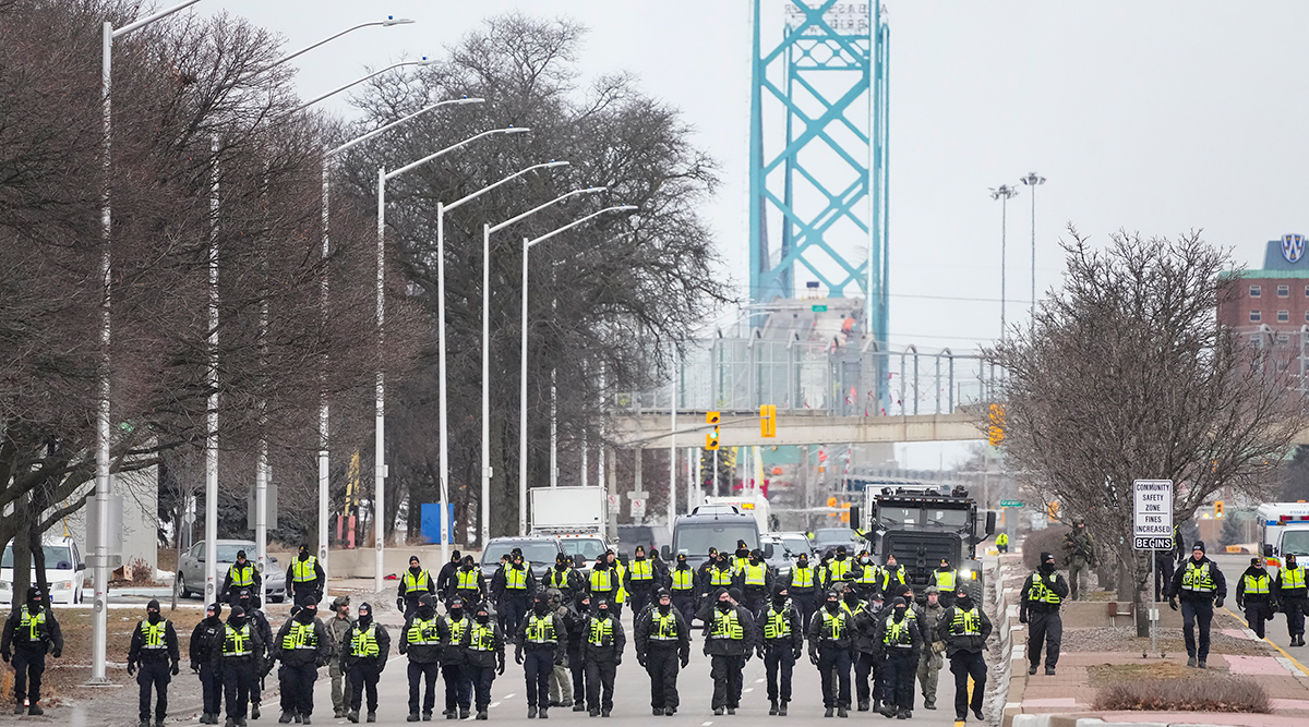  Police walk the line to remove all truckers and supporters in Windsor Feb. 13. 