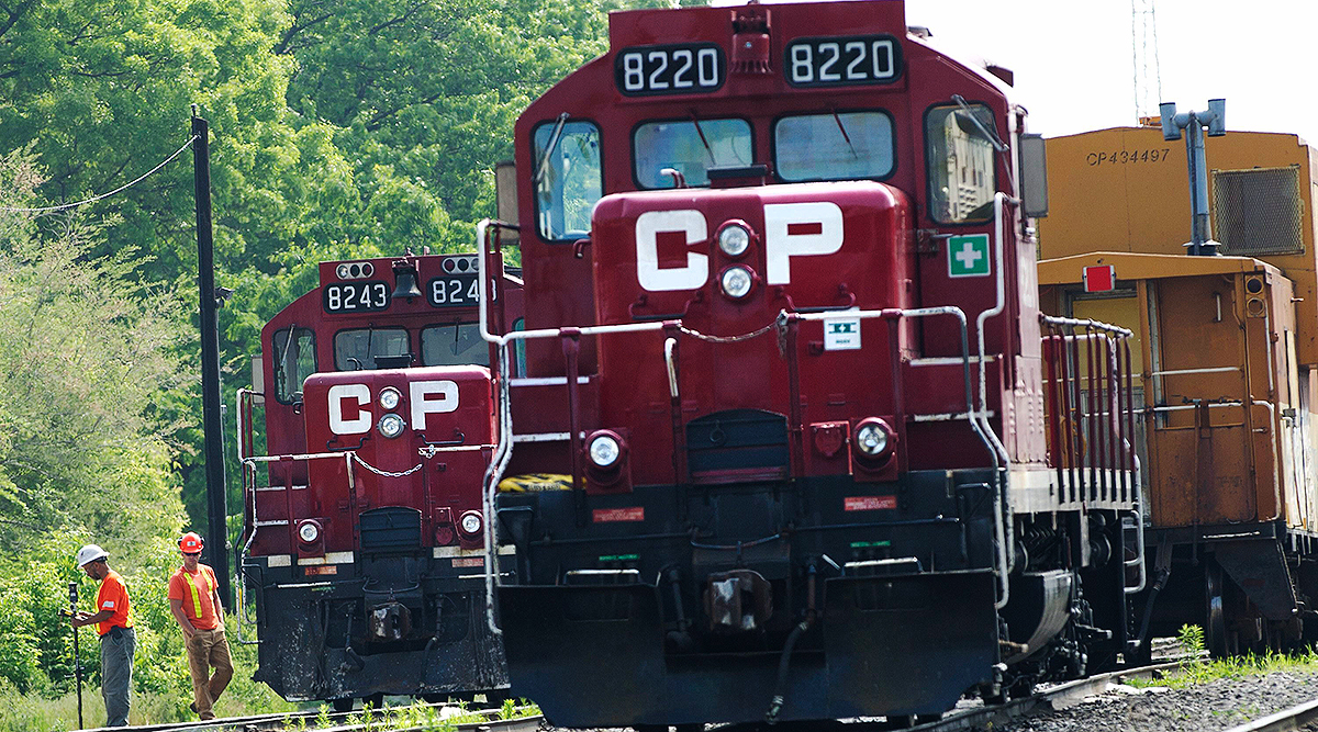 Surveyors work next to Canadian Pacific Rail trains parked on tracks in Toronto
