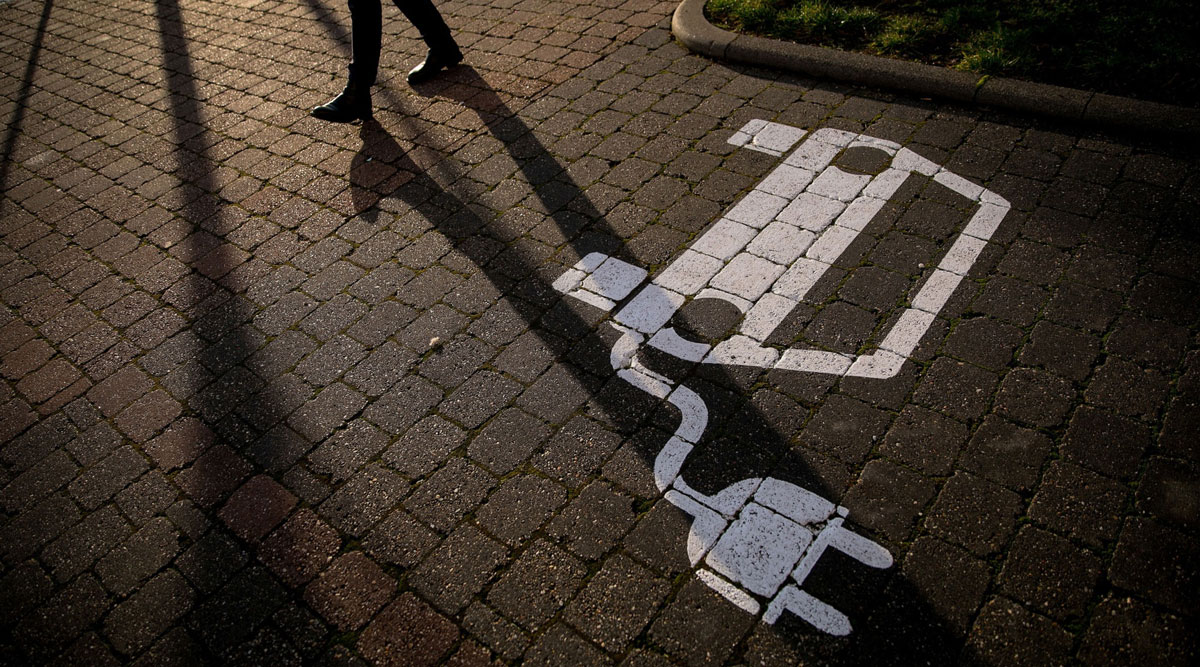 A pedestrian passes an electric vehicle charging space in Germany on Jan. 13.