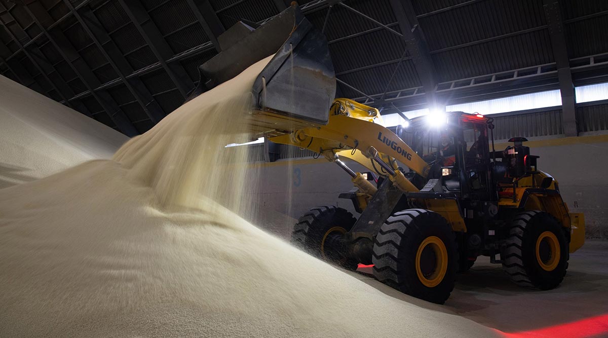 A worker moves granules of phosphate fertilizer in a storage warehouse in Russia
