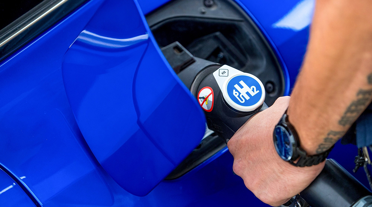 An employee refuels a H2 Mobility branded Toyota Motor Corp. Mirai hydrogen fuel cell electric vehicle
